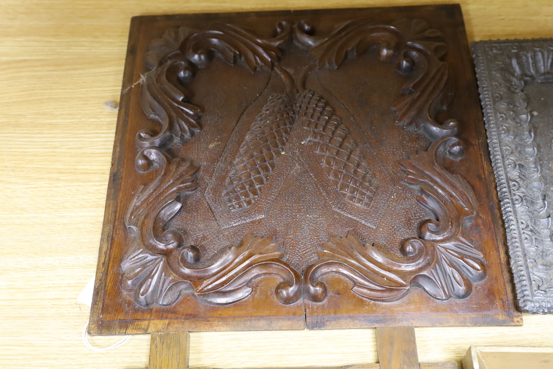 Three assorted cast metal panels together with a carved walnut panel, 39x40cm